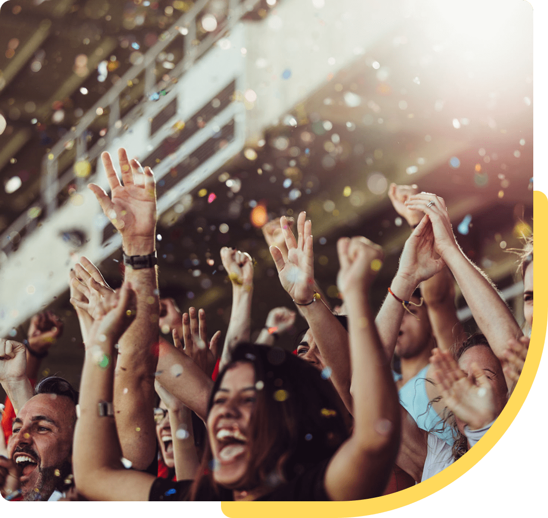 Cheering crowd celebrating with confetti flying.