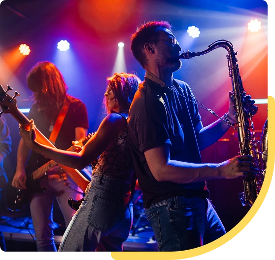 Band performing energetically on colorful stage.