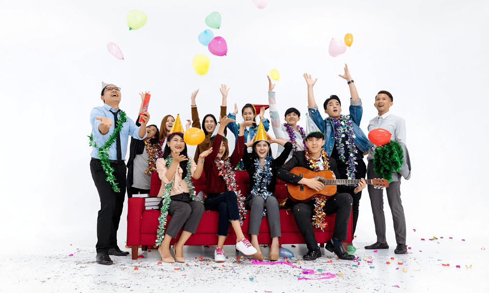 Group celebrating with balloons and confetti.